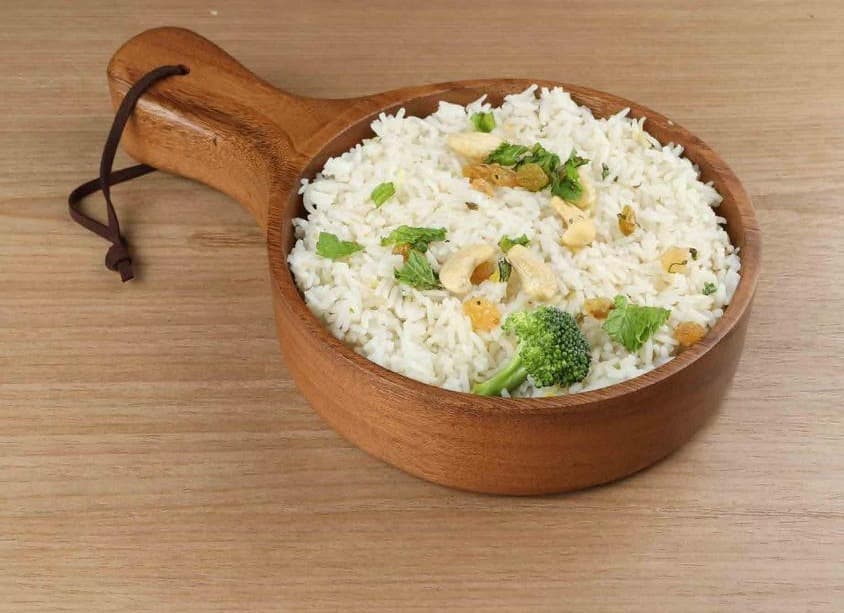 Rice with cashews, raisins and mint served in a wooden bowl